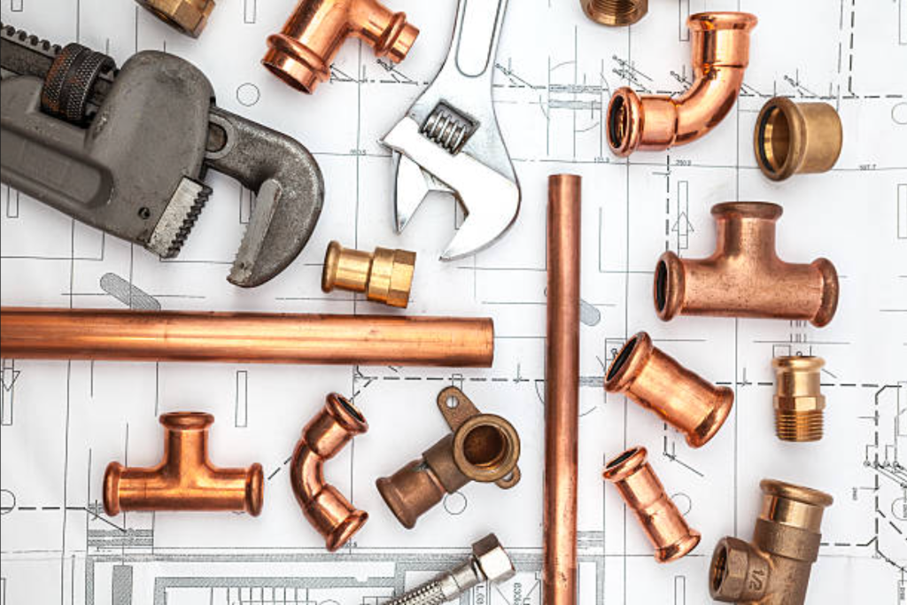 Copper plumbing pipes and fittings on blueprint