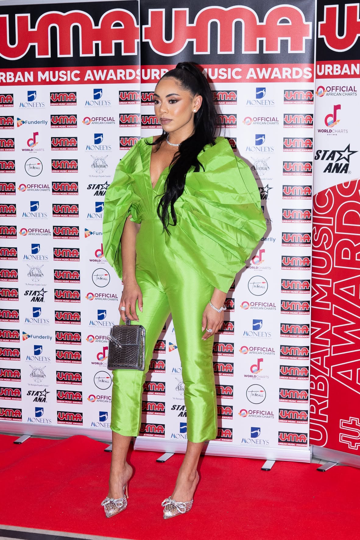 Guest in a lime-green jumpsuit on the UMA red carpet