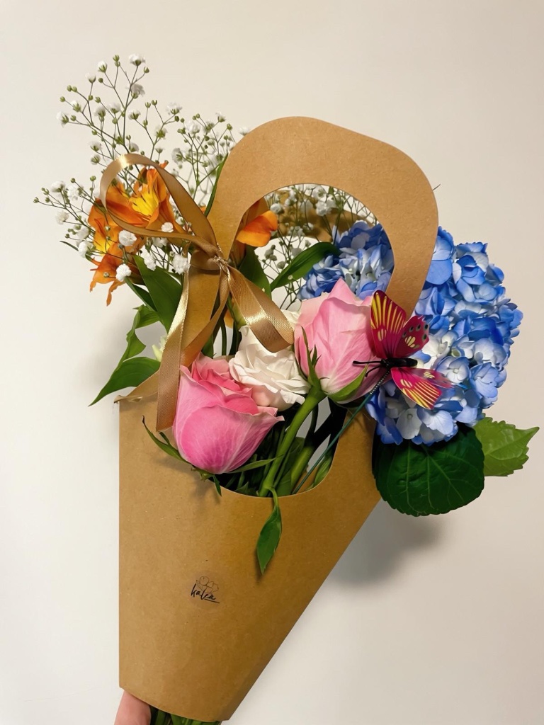 Pink rose and hydrangea arrangement in kraft paper bag by Kalea Arrangements