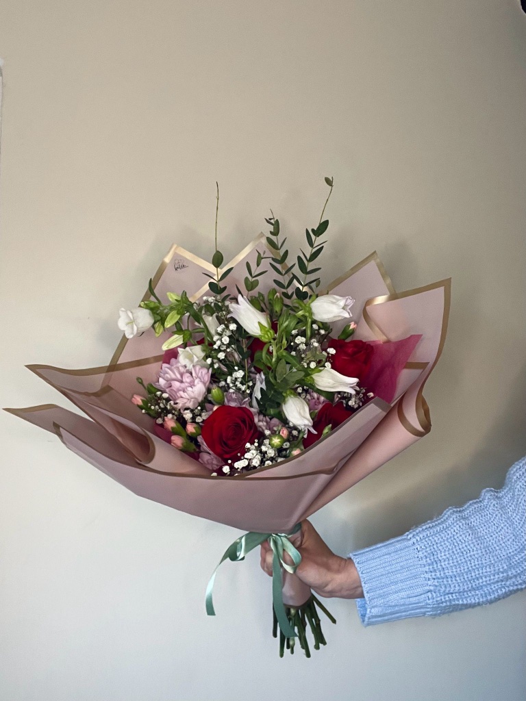 Blush and lavender flower arrangement with roses and statice