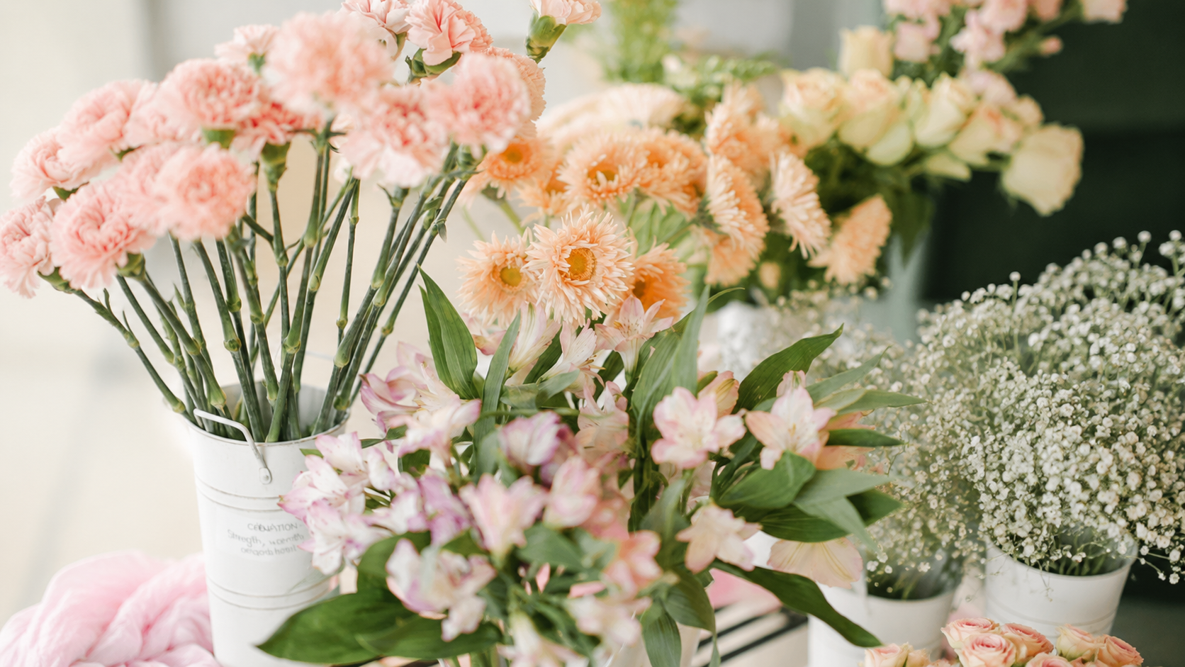 Flower bar setup for an event - glass vases and seasonal flowers on a styled display table