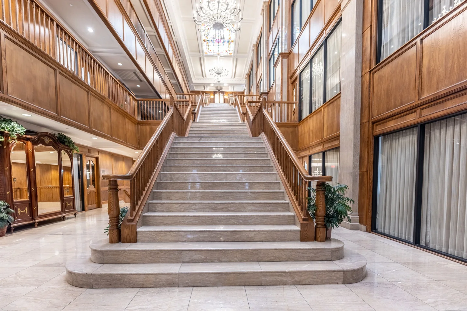 Interior staircase with marble steps and stained-glass ceiling at Echo Lane Dental
