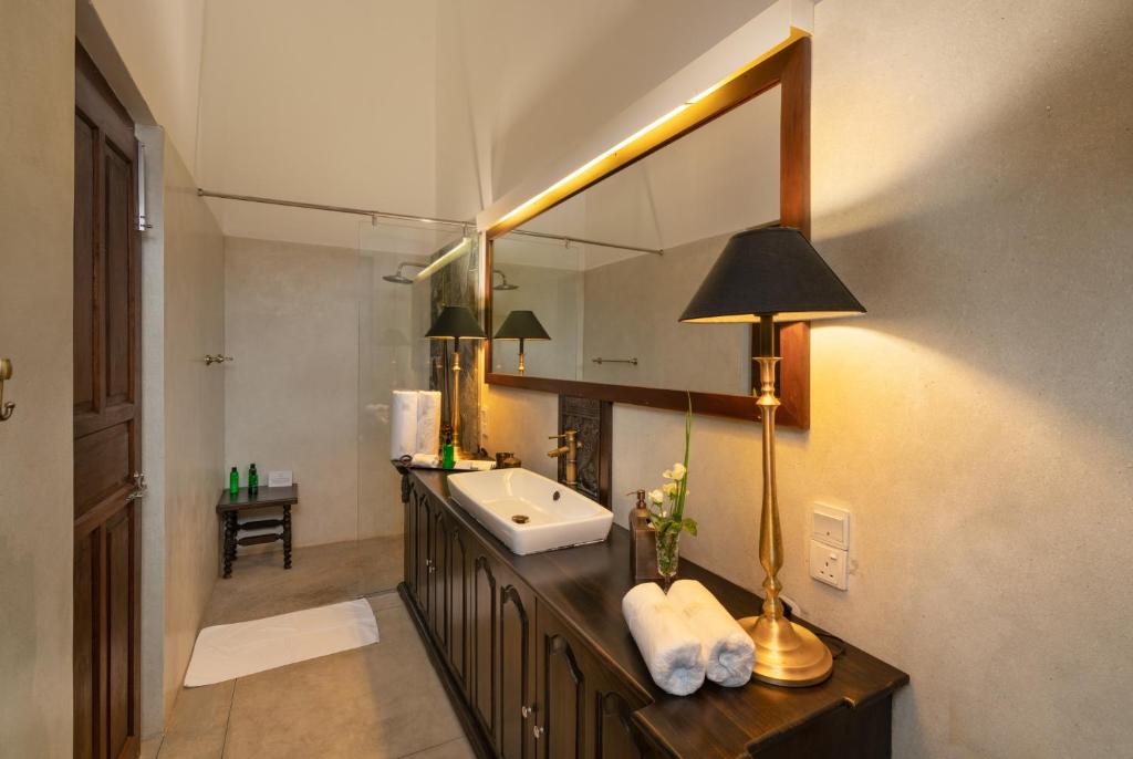 Bathroom Vanity — Carved Wood Panel & Warm Brass Lamp