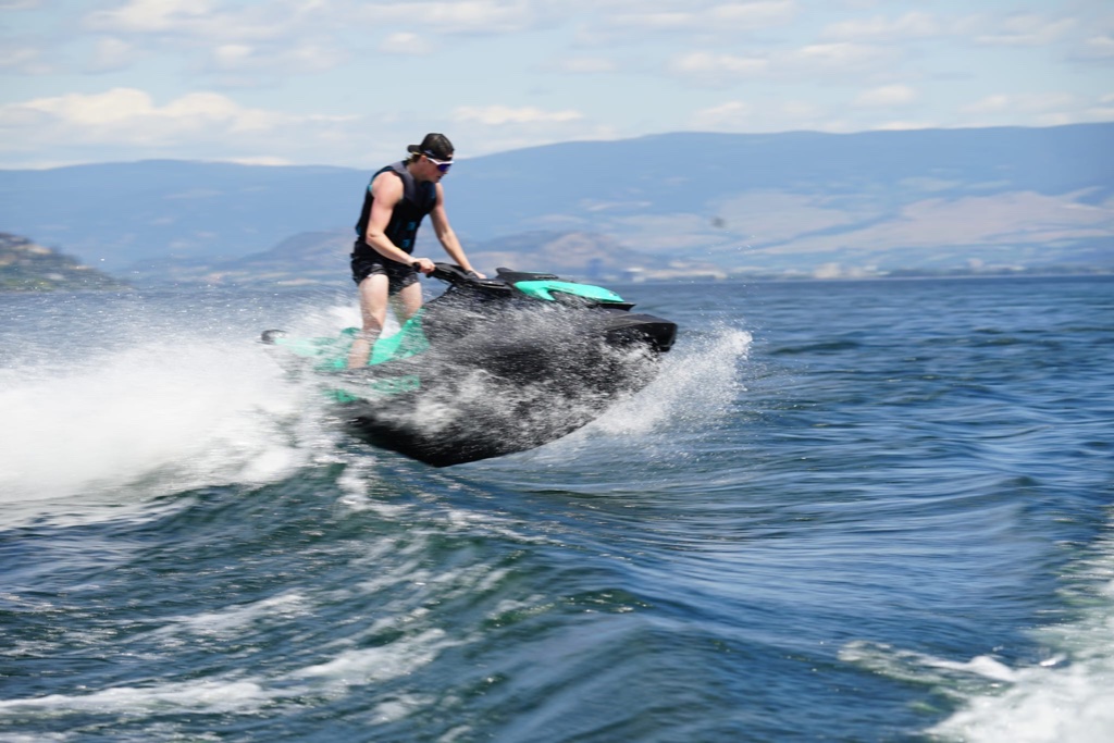 Rider leaning into a turn with visible wake spray on a Sea-Doo GTI SE 170