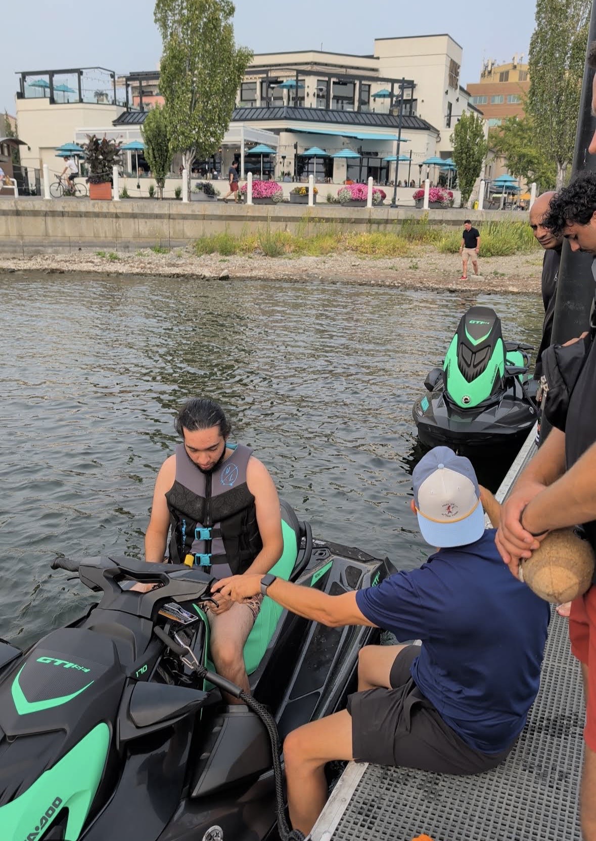 Staff member giving a rider a safety briefing on a Sea-Doo at the dock on Okanagan Lake