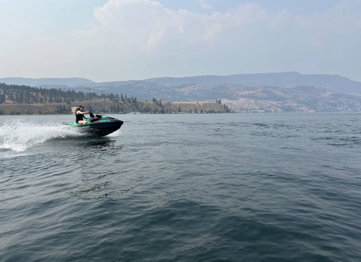 Guest riding a Sea-Doo and carving a white wake across Okanagan Lake