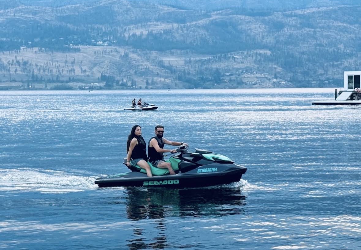 Two riders cruising together on a Sea-Doo across Okanagan Lake