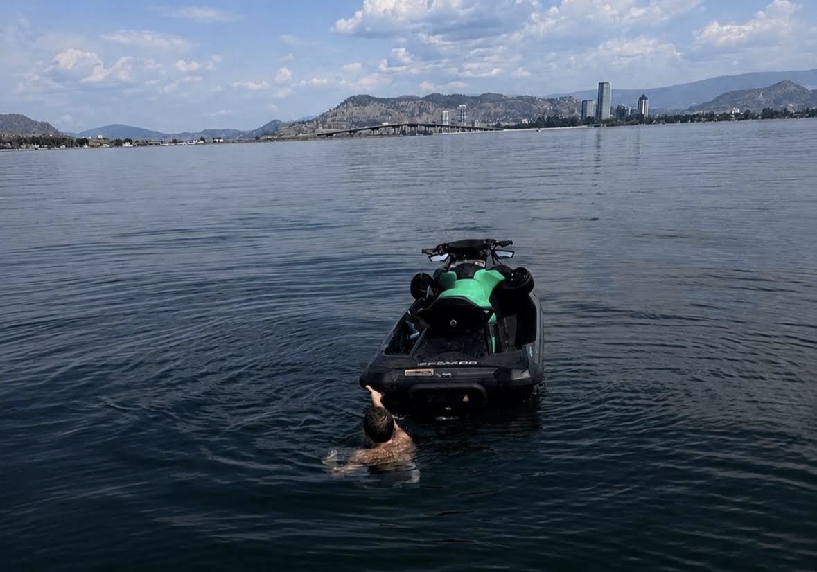 Guest swimming toward a Sea-Doo on Okanagan Lake near the Kelowna waterfront