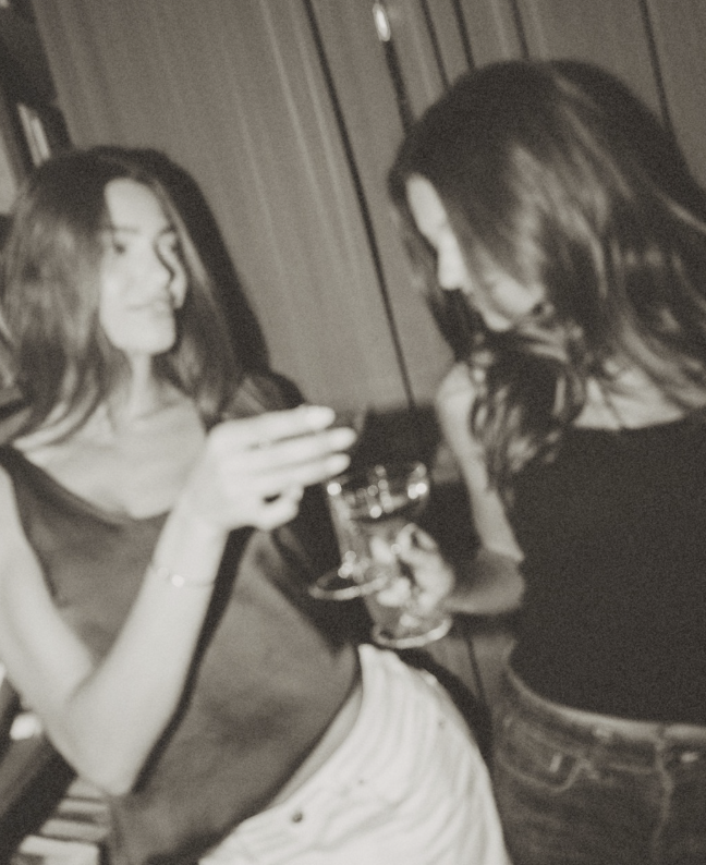 Guests cheering in an Accomplice photobooth, black and white film-grain photo