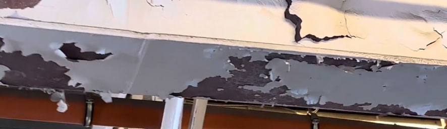 Severe fireproofing delamination exposing bare steel substrate