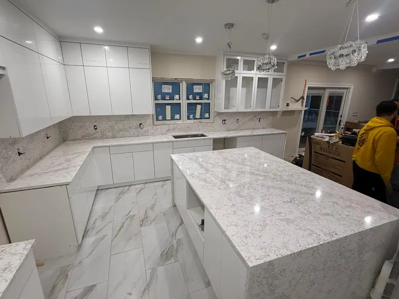 Modern L-shaped kitchen with white quartz island and perimeter counters with grey marbling, Schenectady