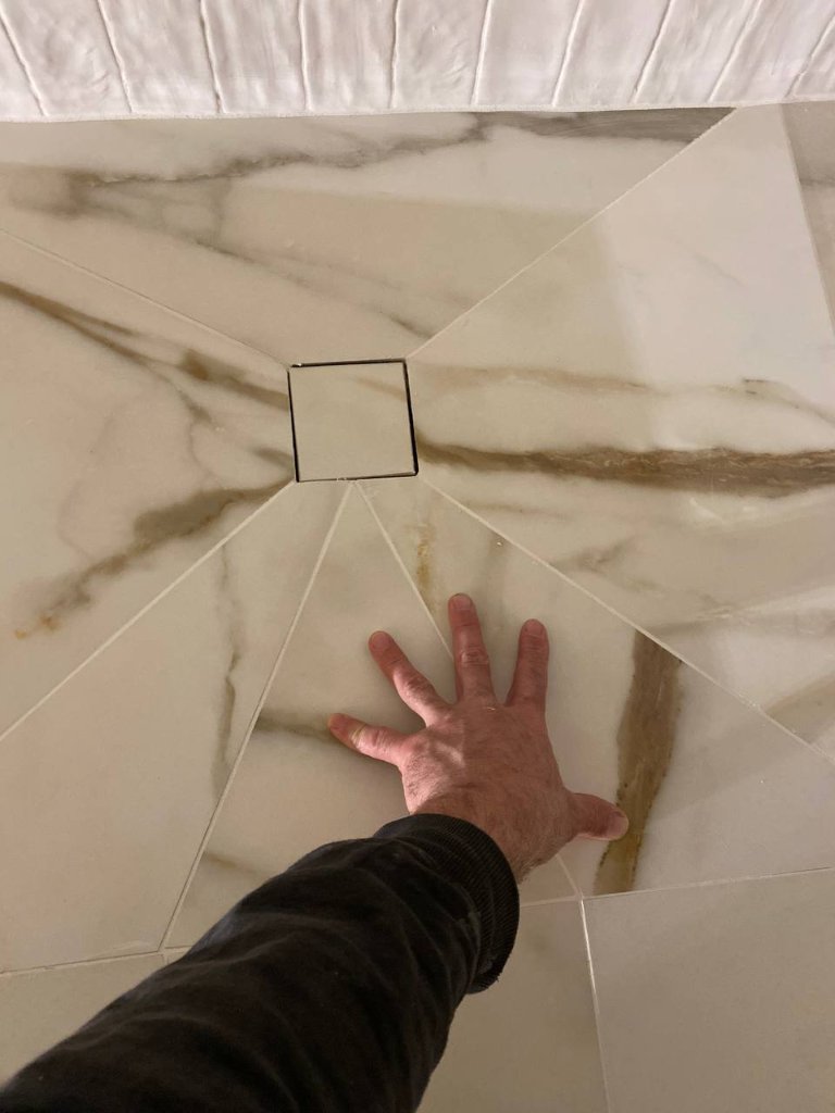 Geometric star tile pattern cut around center drain