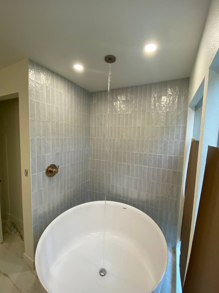 Ceiling-mount waterfall tub filler over round soaker