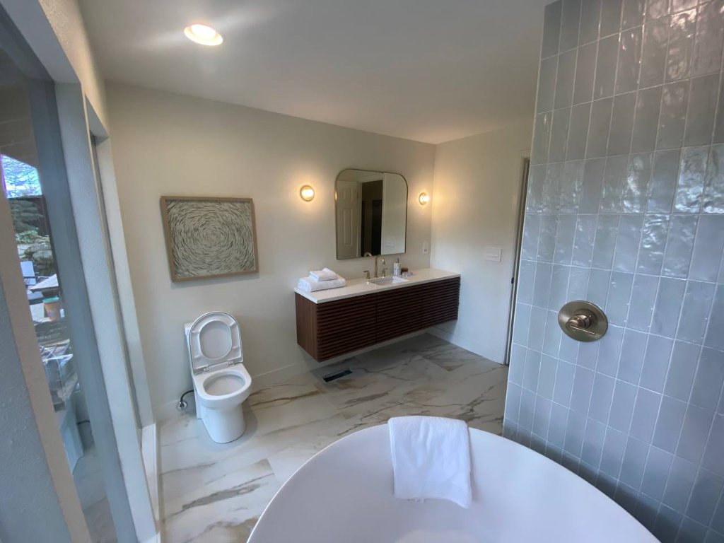 Second bathroom — zellige tile, round soaker, ceiling waterfall filler