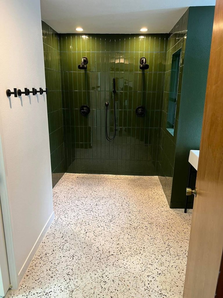 Curbless walk-in shower from hallway — linear drain, green tile