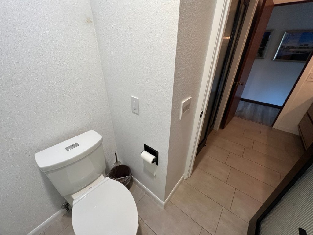 Private toilet room — clean, minimal, recessed toilet paper holder