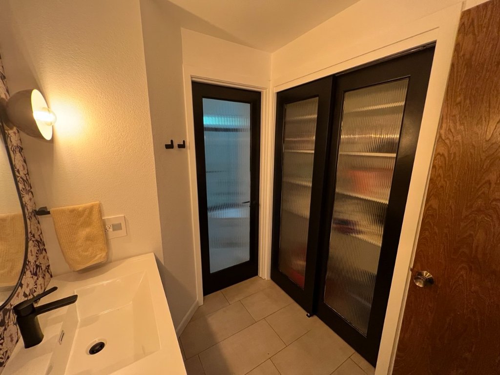 Reeded glass black-framed interior doors — shower and closet