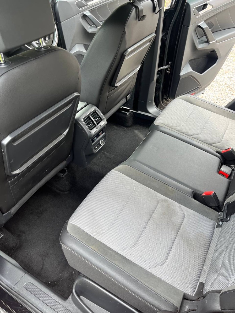 Car seat fabric with visible staining before hot water extraction