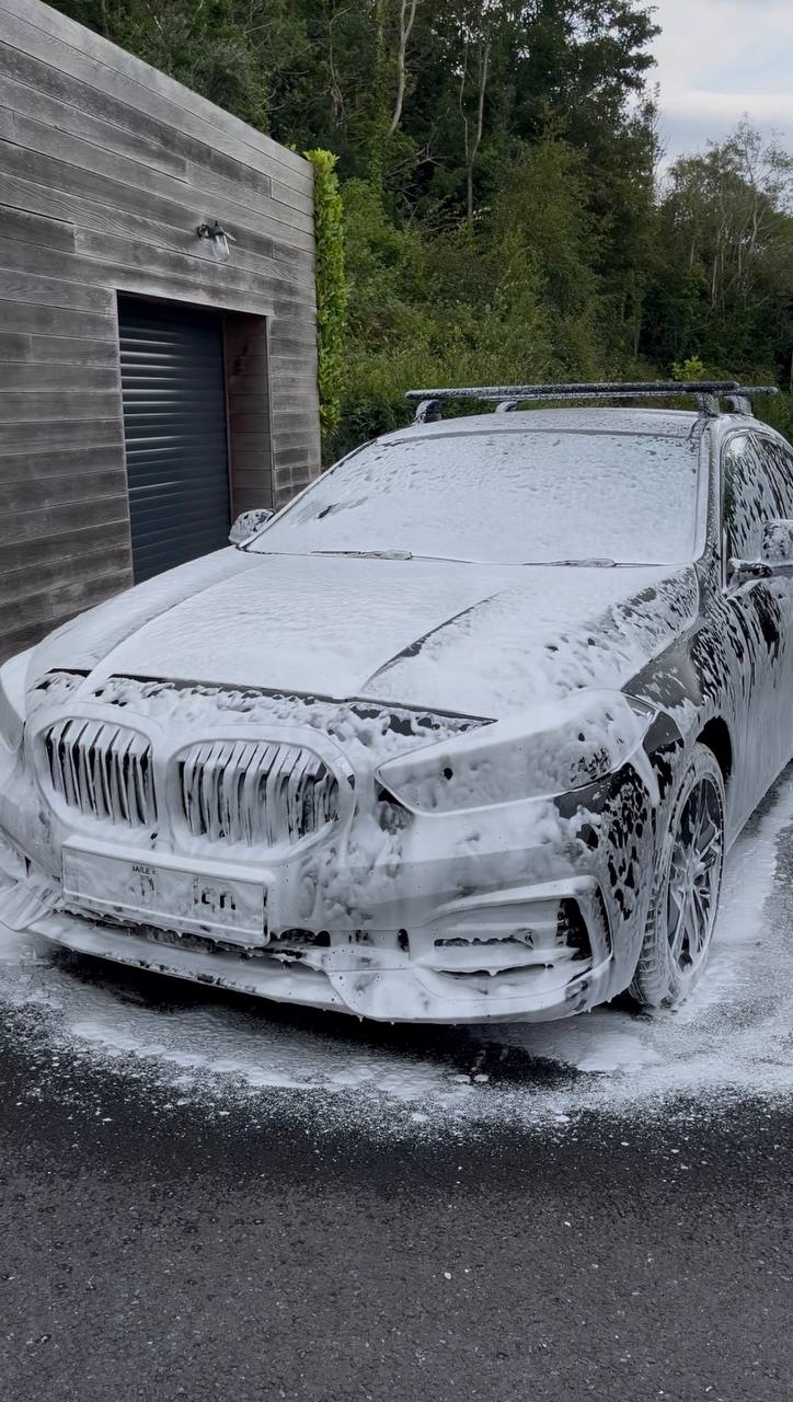 Dark sedan covered in thick white snow foam during a full car valet by NeatAuto in Sligo
