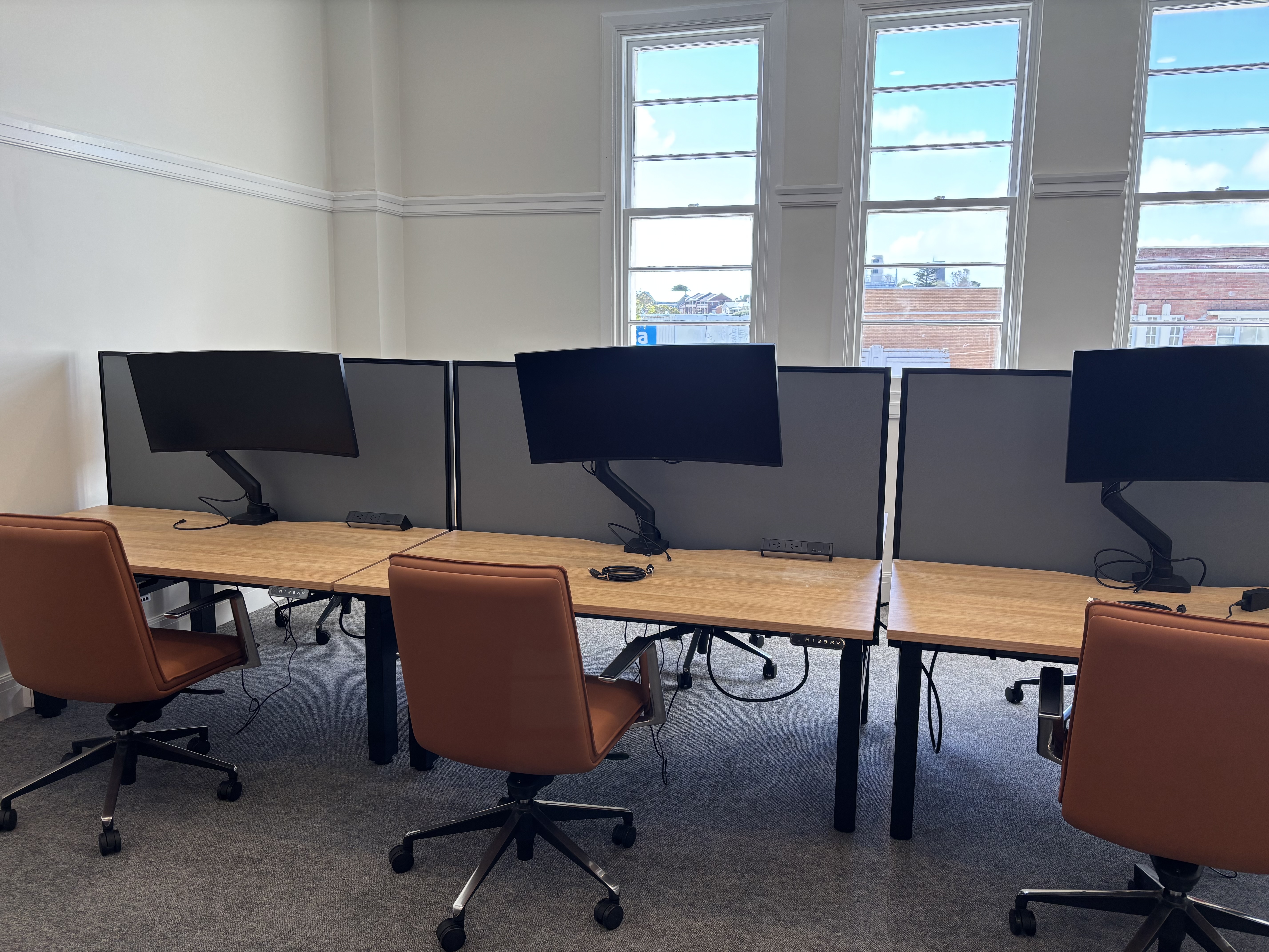 Row of three workstations with curved monitors