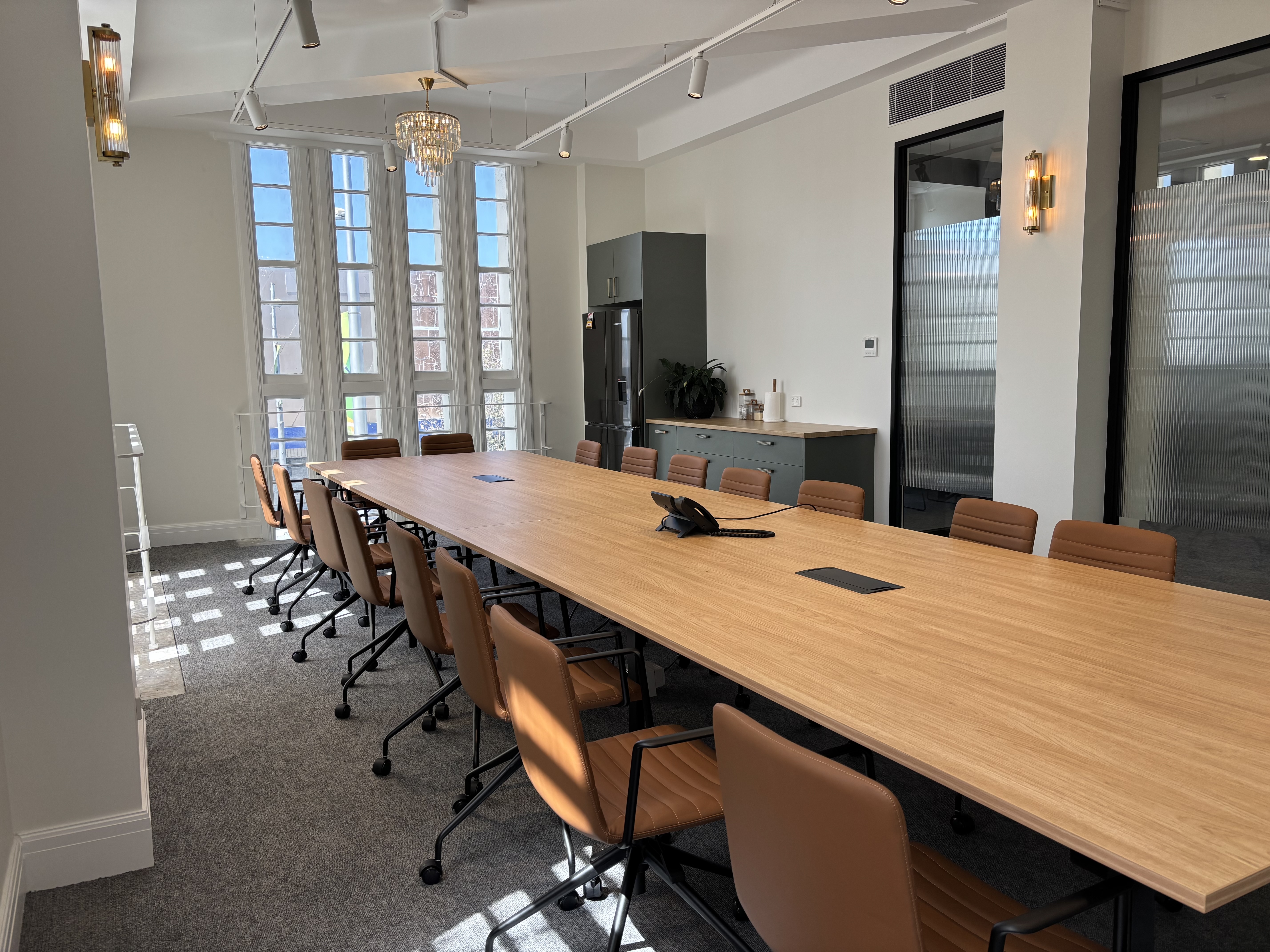 Boardroom with long oak table and tan leather chairs