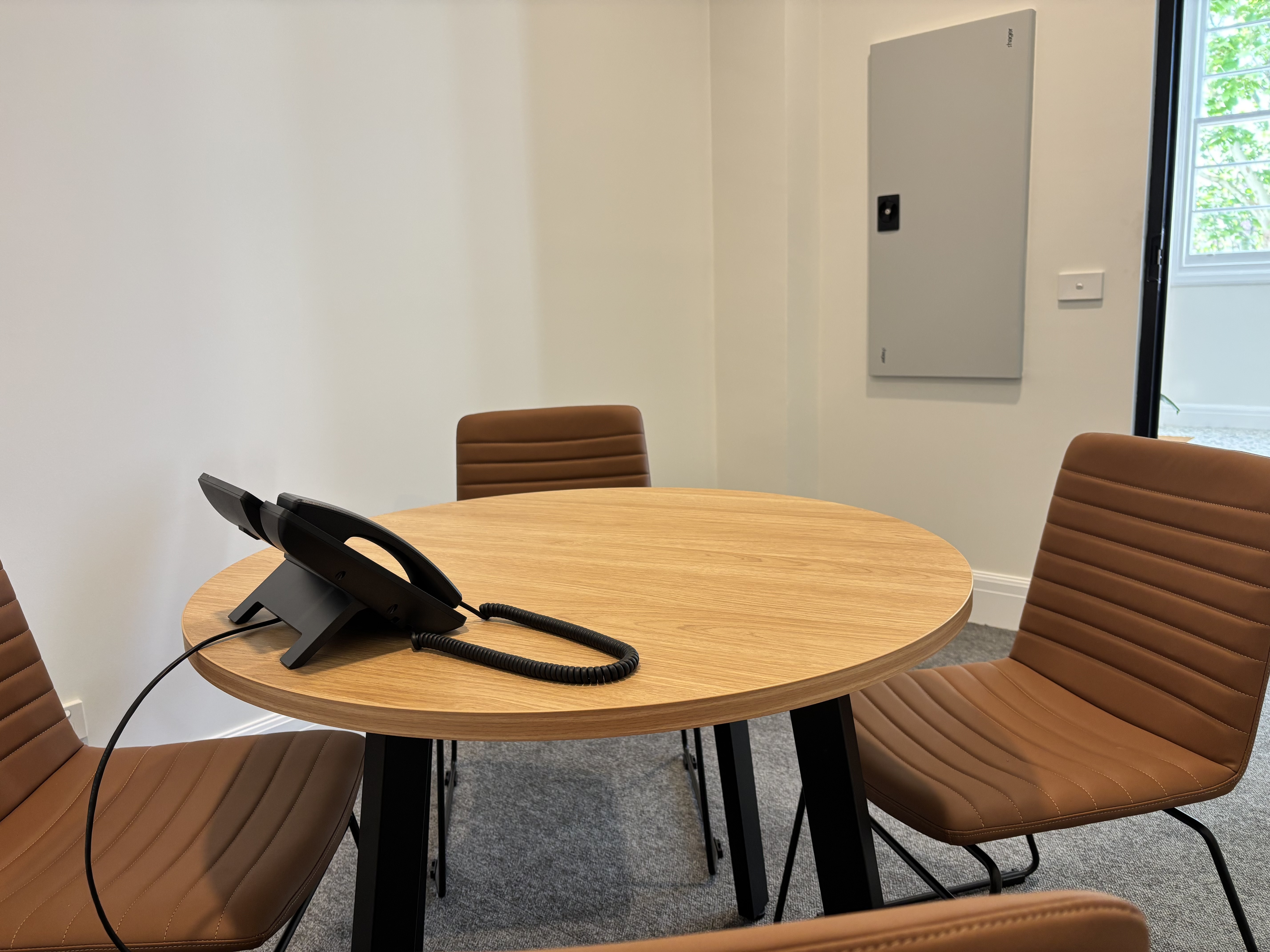 Meeting nook with round oak table and leather chairs