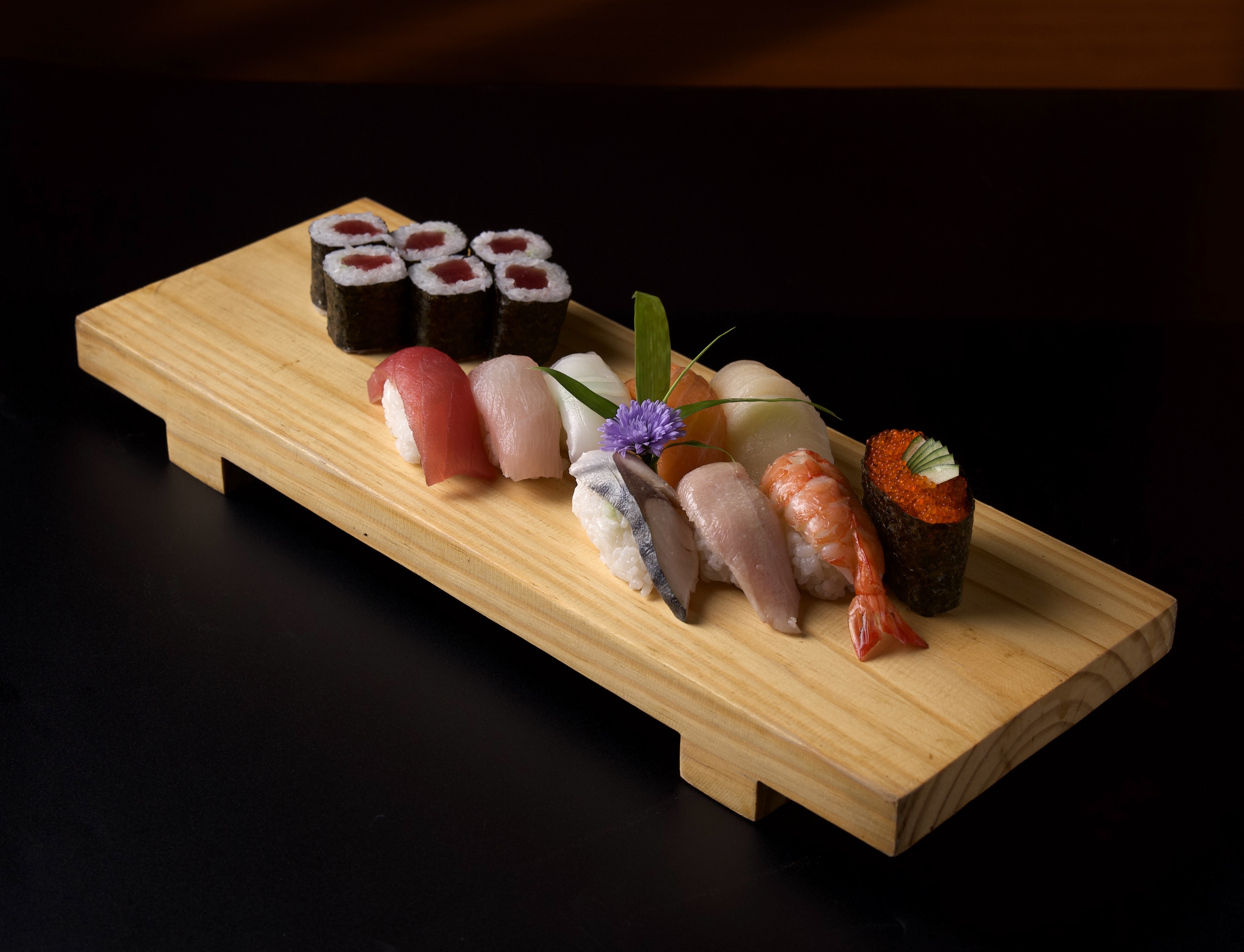Premium nigiri and maki selection on a wooden board at Ginza Hohsen - fresh tuna, salmon, shrimp and hand rolls
