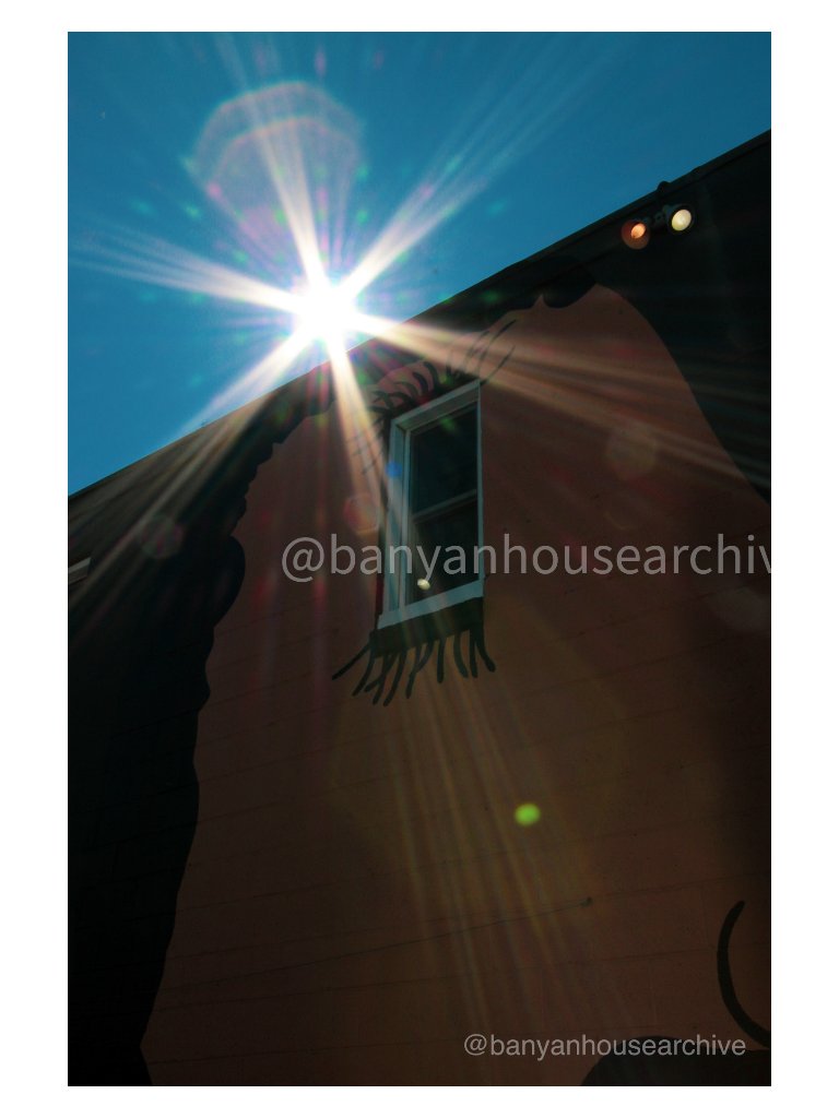 Terracotta wall with painted eye window and sunburst