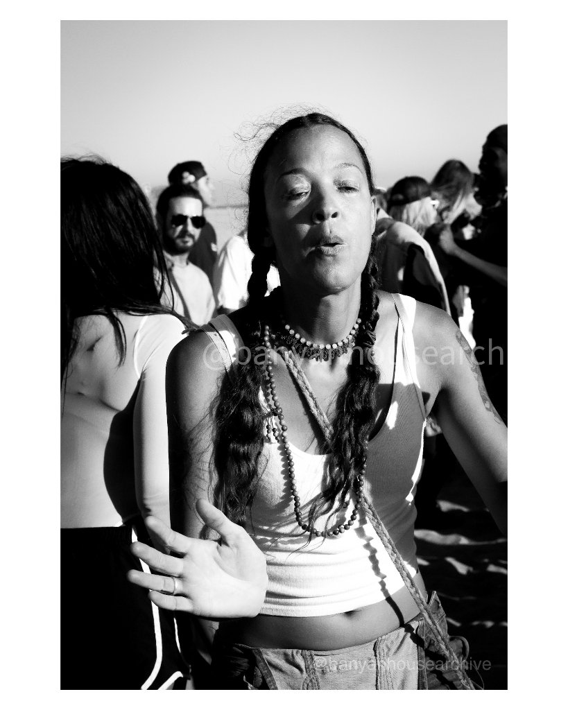 Woman with braided hair at an outdoor event, black and white
