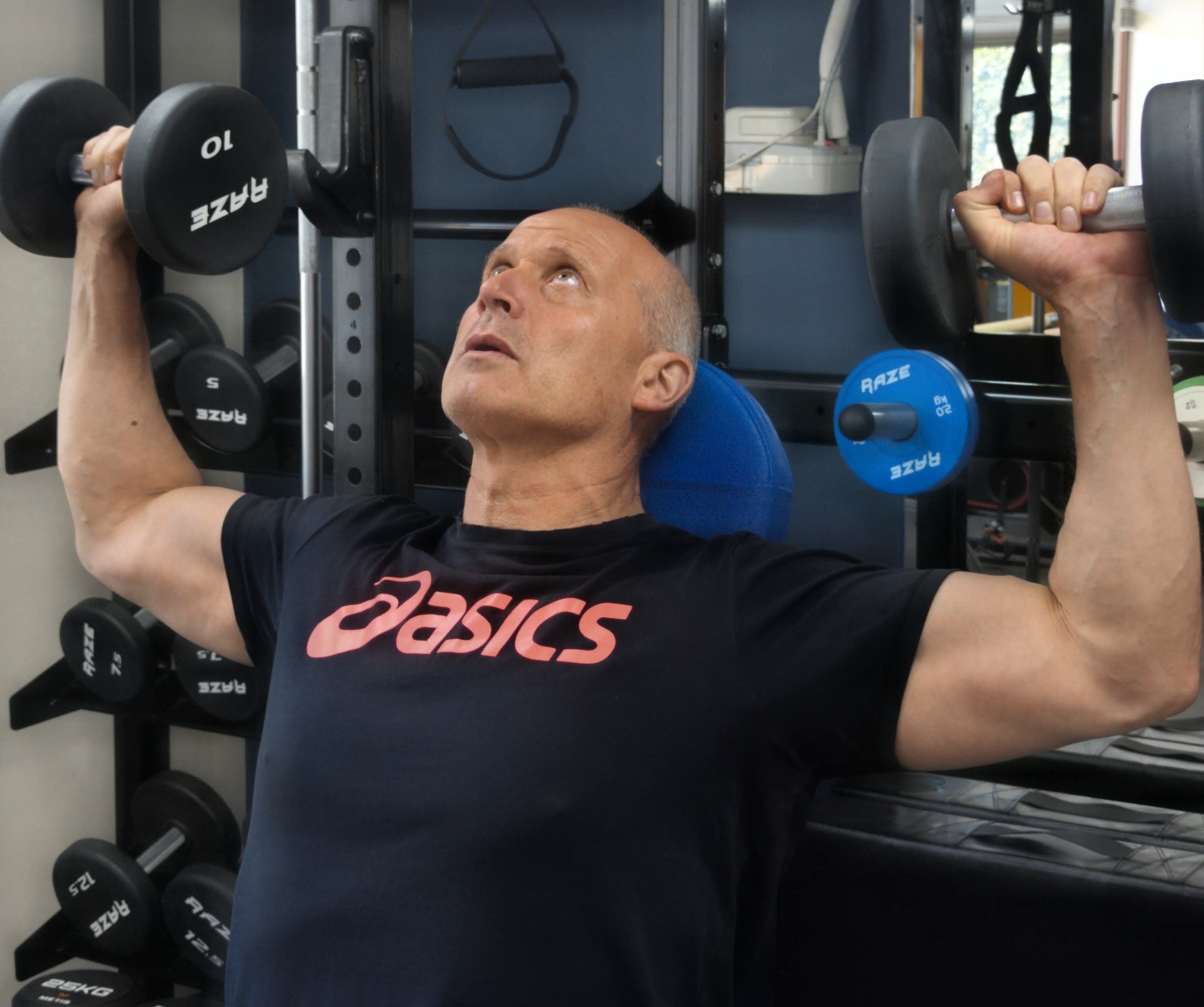 Man performing a seated dumbbell shoulder press