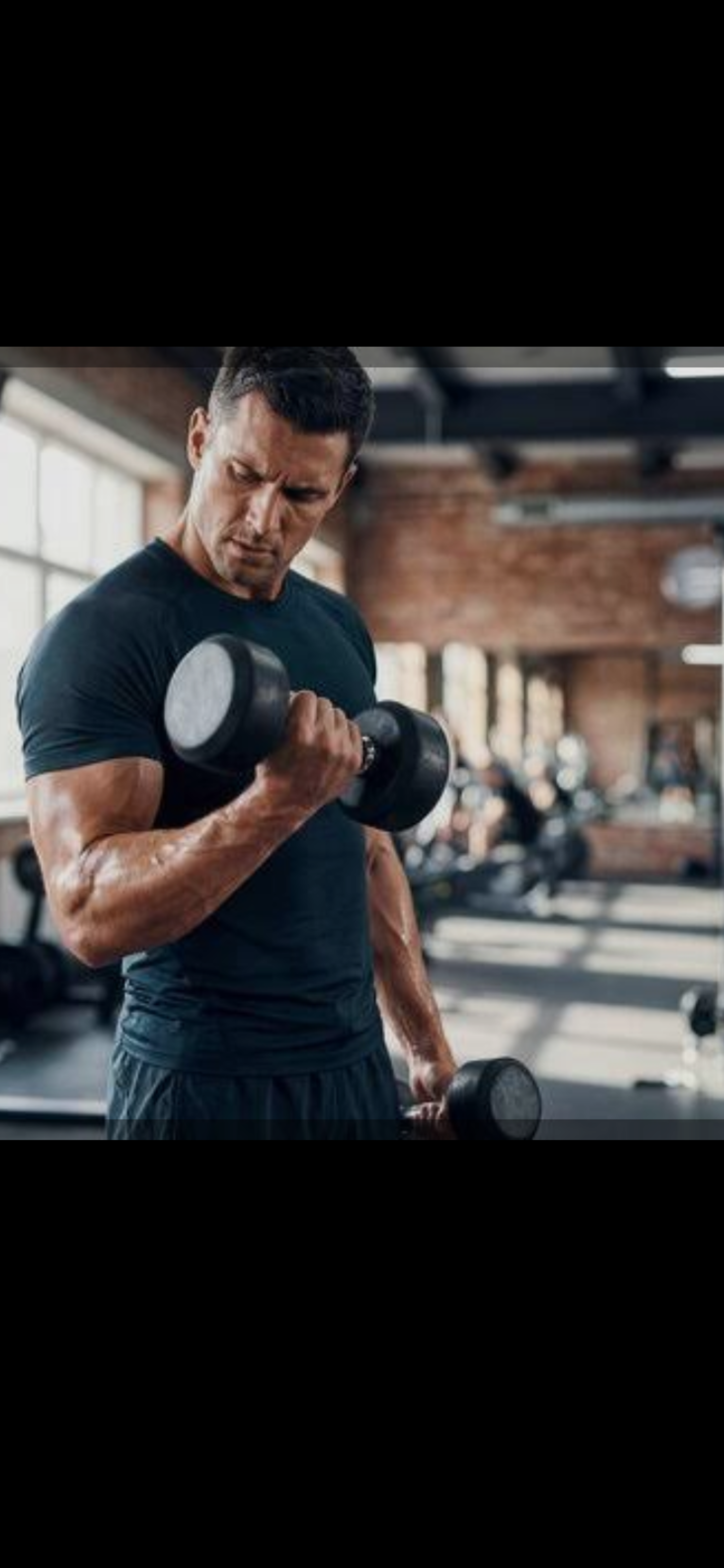 Man performing a bicep curl with a dumbbell in gym