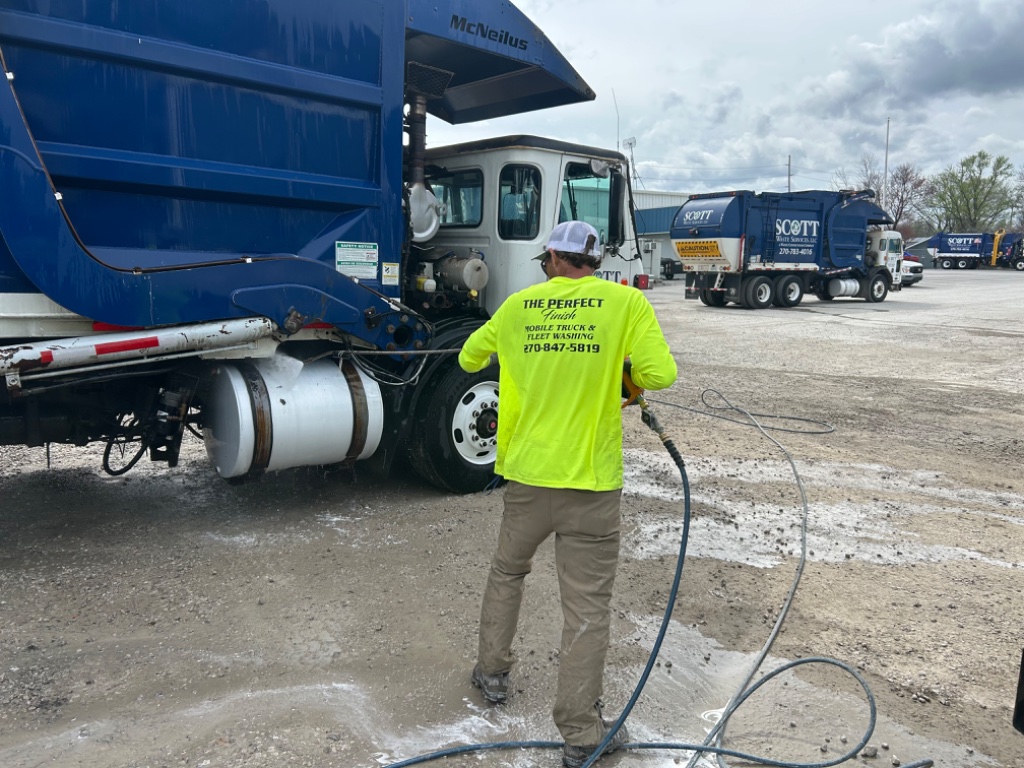 Technician washing commercial truck