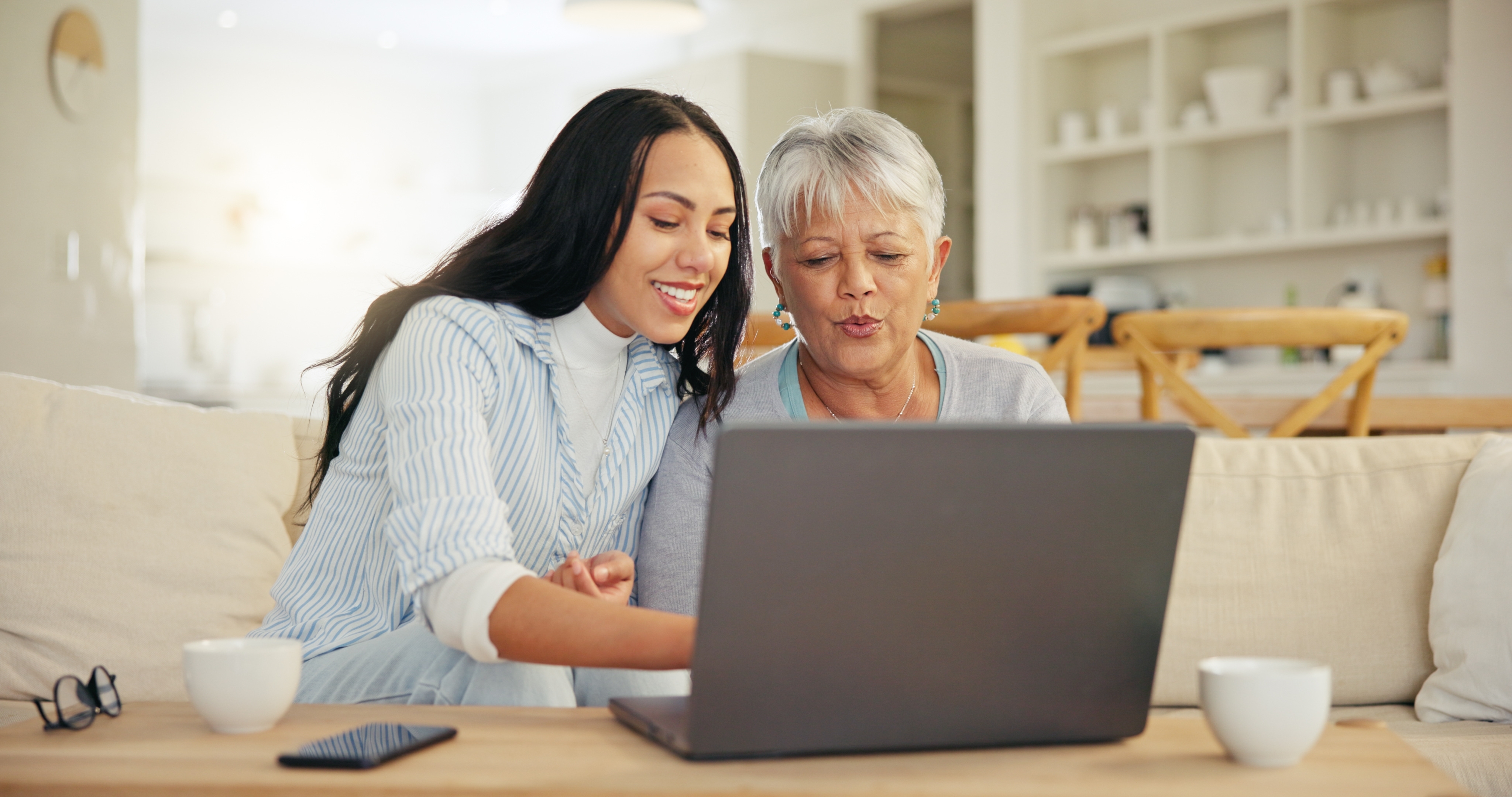 Two women reviewing hormone replacement therapy information together on a laptop at Center Pharmacy