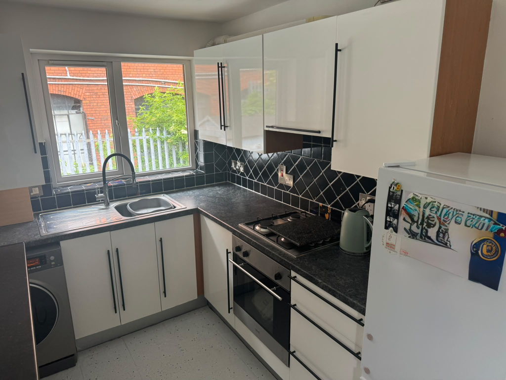 Tired white gloss kitchen with black worktop on the Ards Peninsula before vinyl wrap