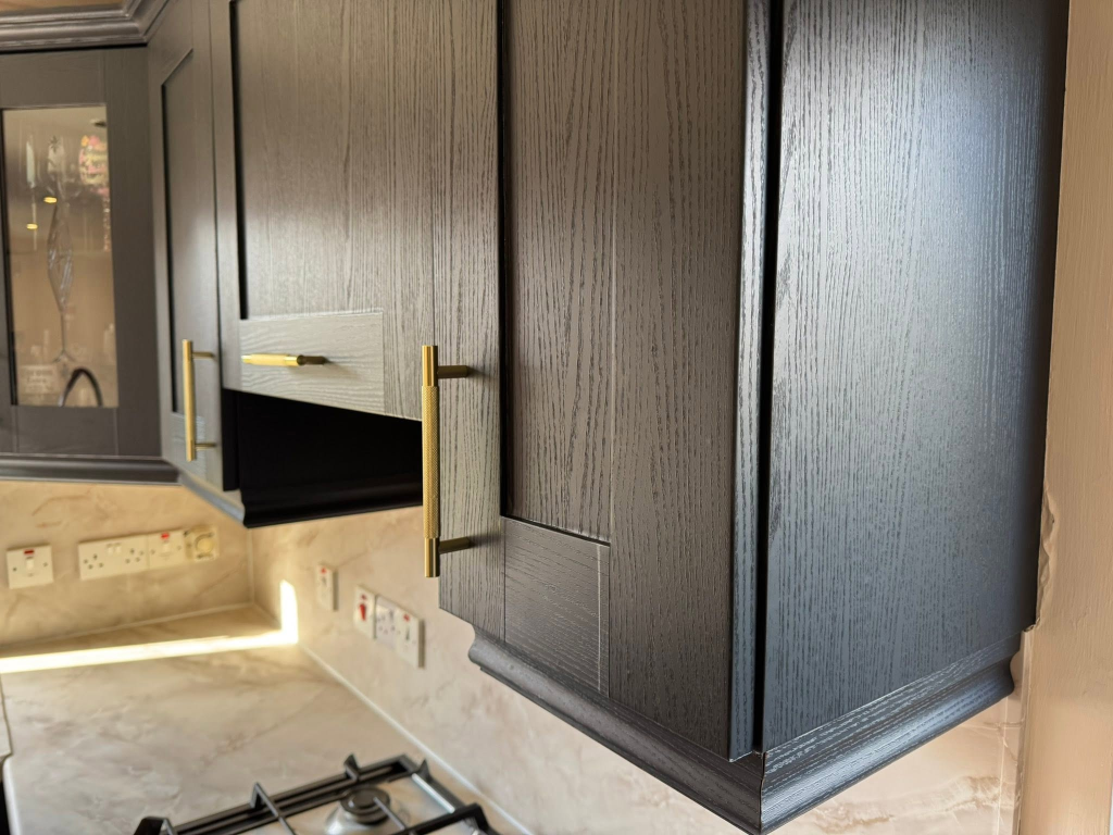Corner detail of black wood cabinet meeting open shelf unit with marble backsplash