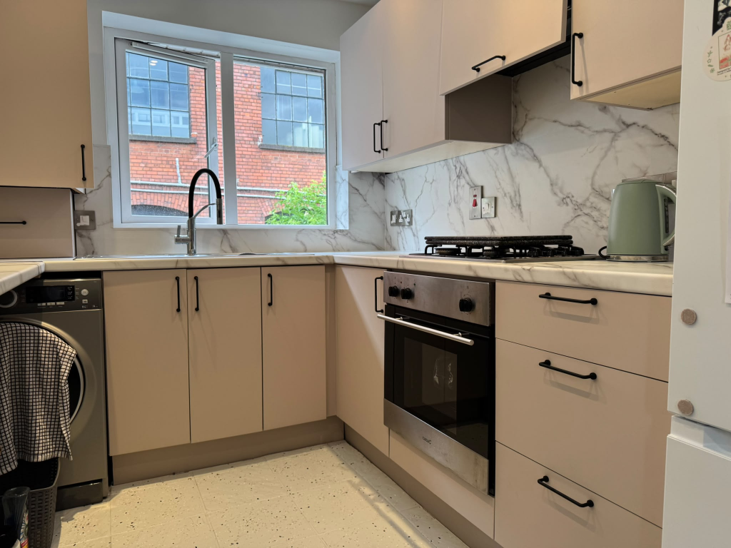 Same Ards Peninsula kitchen transformed with greige vinyl cabinets and marble-effect worktop