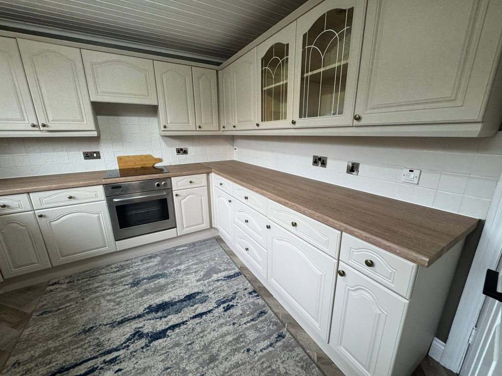 Eye-level view of renovated kitchen corner with oak worktop
