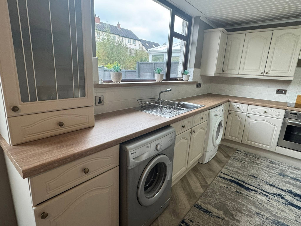 Wide angle of kitchen with dark oak vinyl worktop wrap