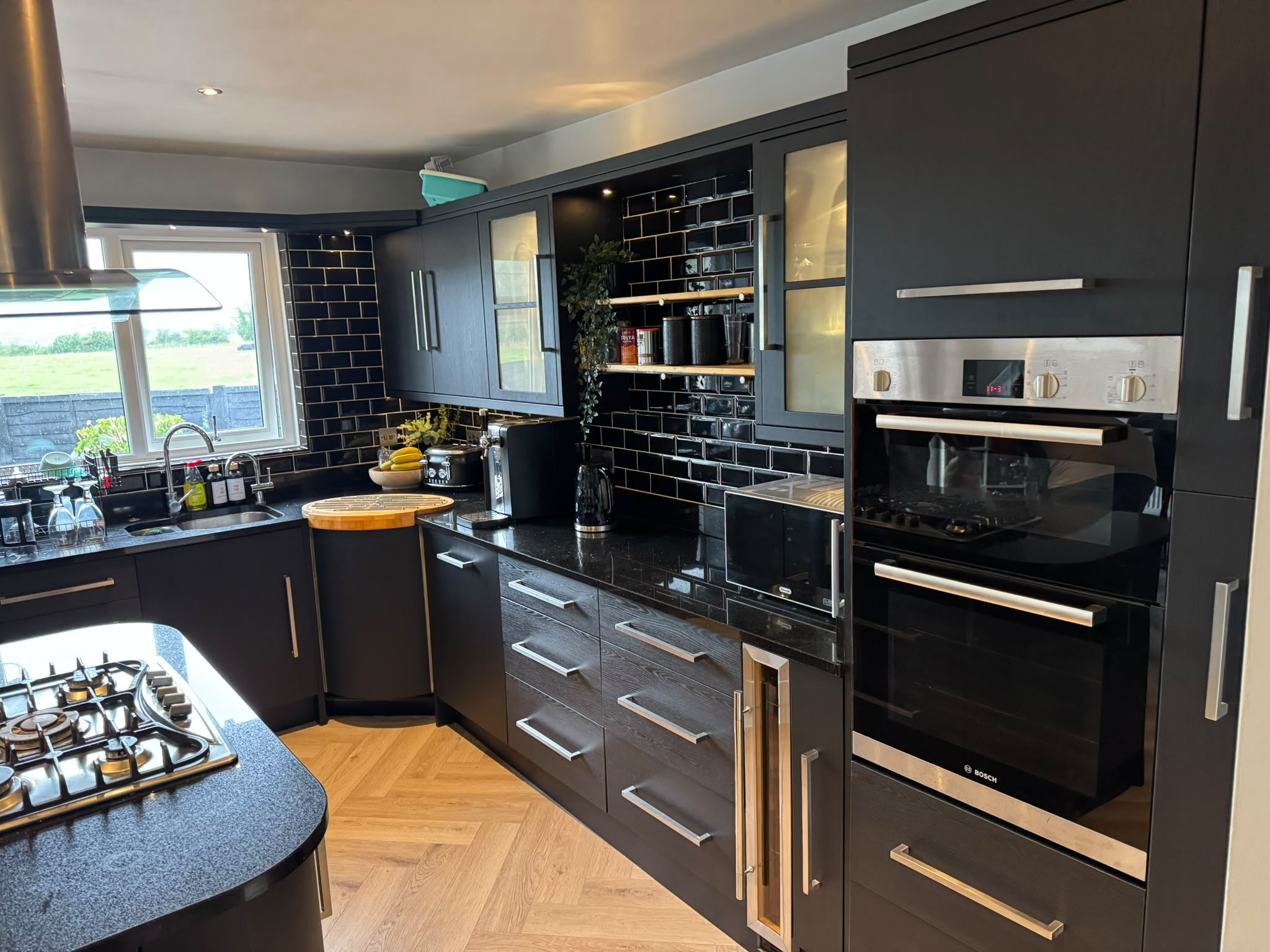 Same kitchen transformed with black wood-grain cabinet wrap