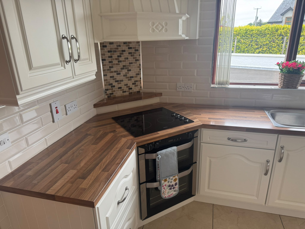 Kitchen with light wood laminate worktop and white cabinets before wrap