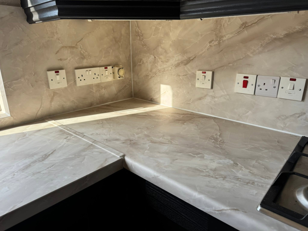Marble-effect worktop and backsplash corner with electrical sockets