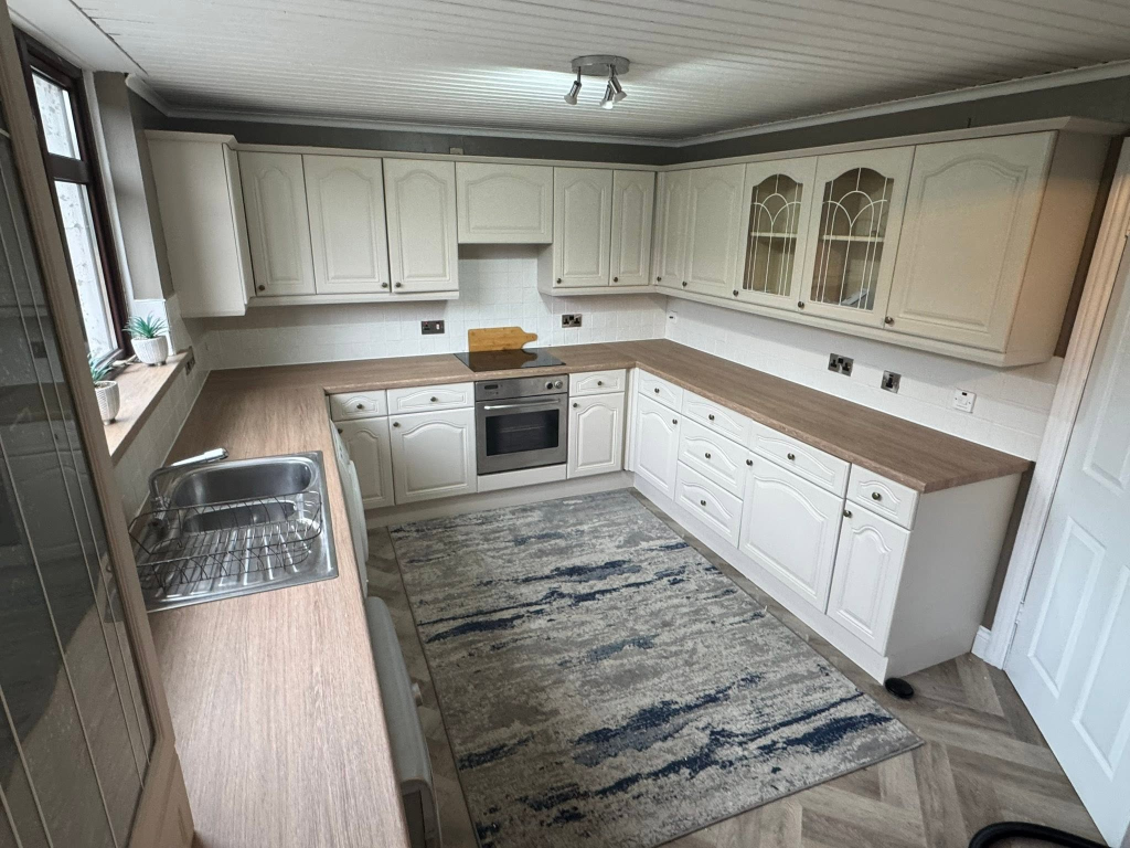 U-shaped kitchen with dark oak wrapped worktops and window sill