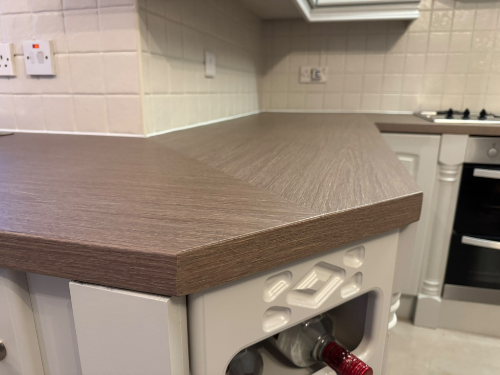 Same worktop corner transformed with clean wood-grain vinyl wrap