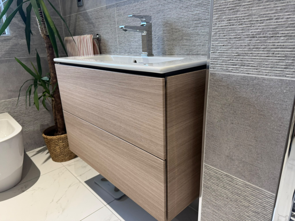 Same vanity wrapped in light oak wood-grain vinyl