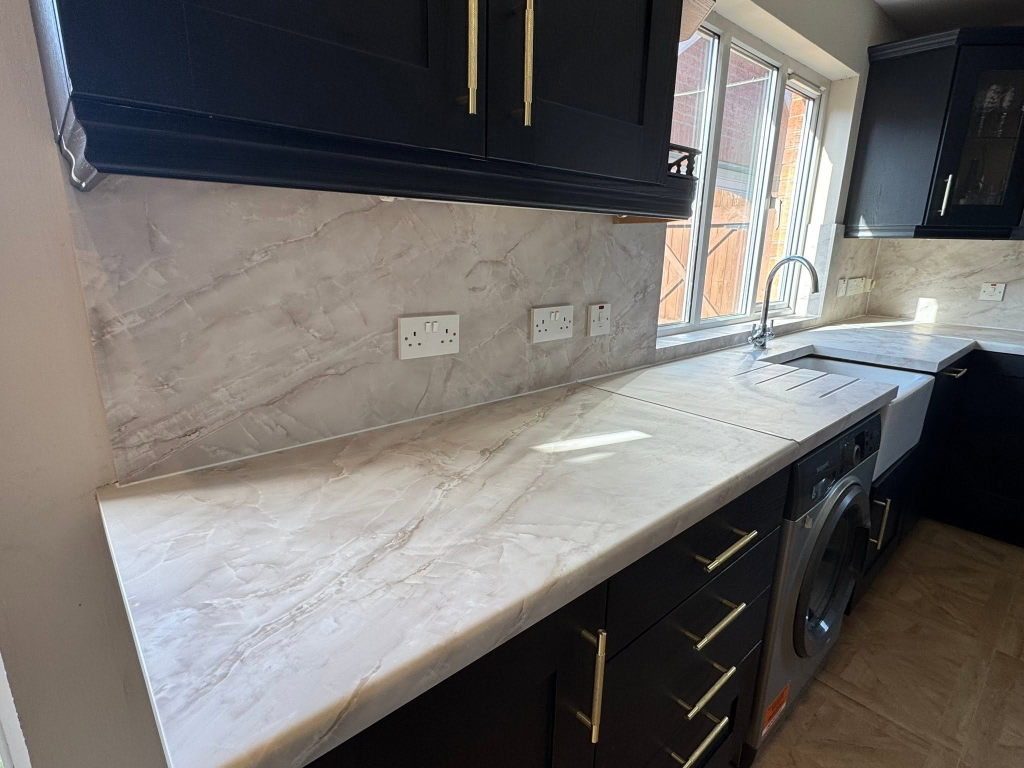 Left section of wrapped kitchen with washing machine and marble splashback