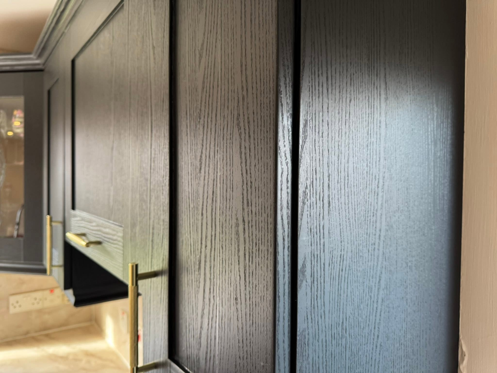 Texture close-up of black wood-grain vinyl wrap with gold knurled handle
