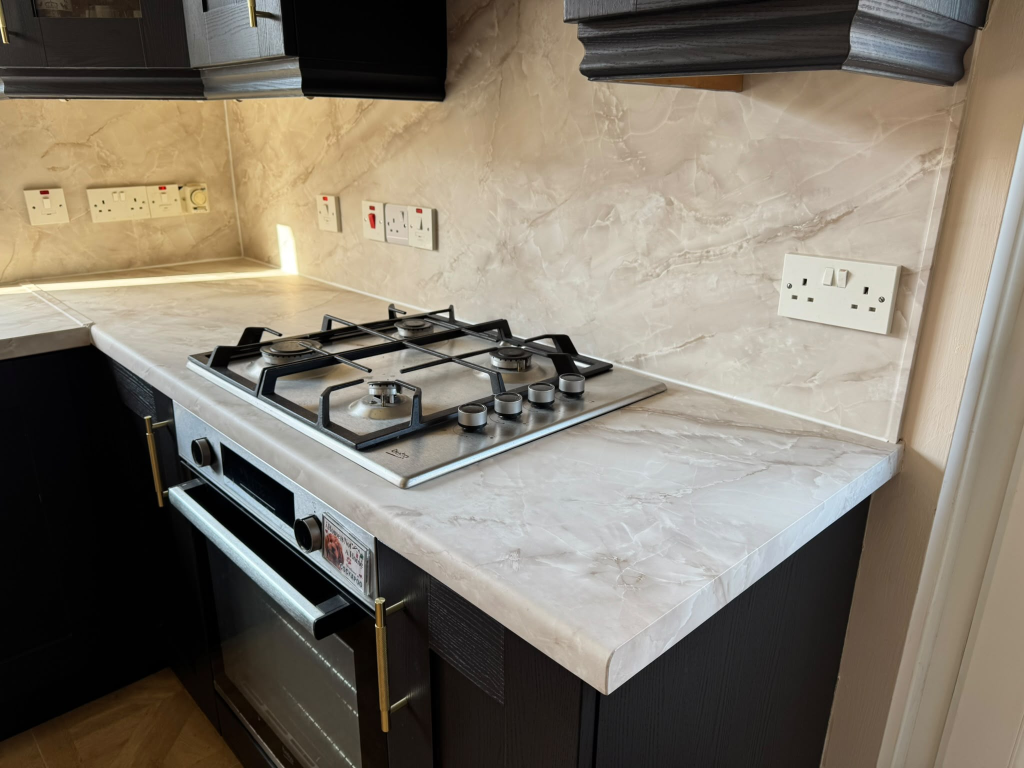 Craftsman hand smoothing premium architectural vinyl onto a kitchen worktop