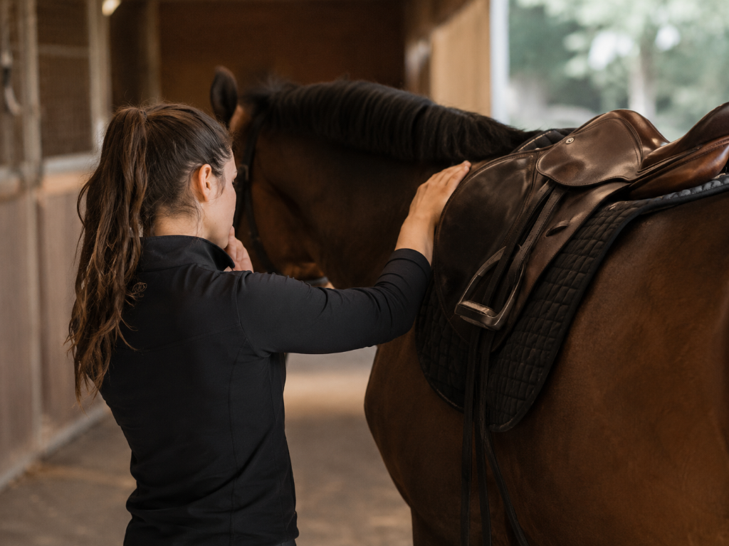 Cavalière pensive inspectant la selle de son cheval