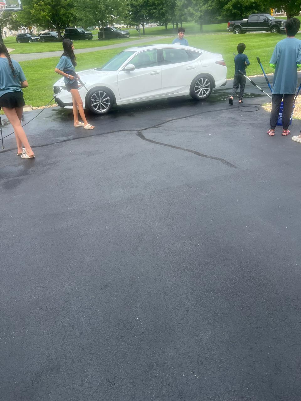 Kids pressure washing the car