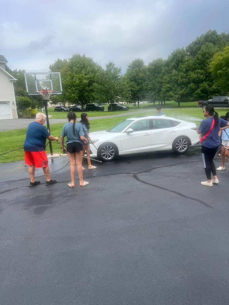 Volunteers washing the white sedan